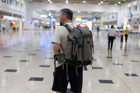 Traveler in airport on his phone checking the directions for his flight. High quality photoの写真素材