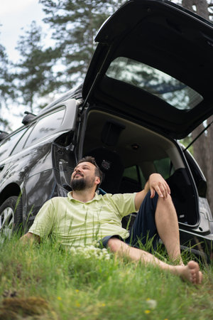 Man Lying in Grass Looking at Trees from Car. High quality photoの写真素材