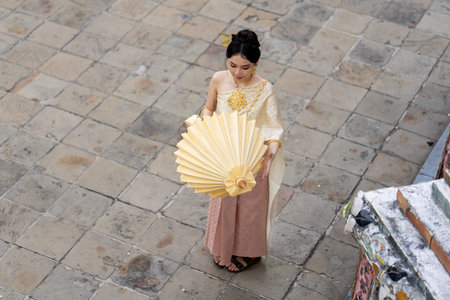 Beautiful Asian woman posing for photograph wearing traditional clothing at Wat Arun Buddhist temple. High quality photoの写真素材