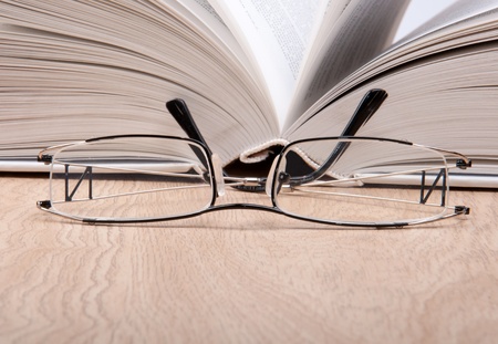 open book with glasses on tableの写真素材