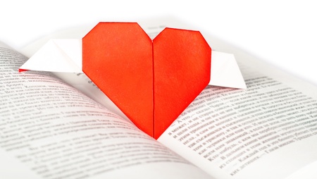 A paper origami heart on a bookの写真素材