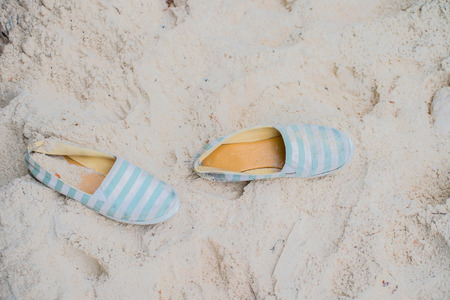 a pair of shoes on the sandの写真素材