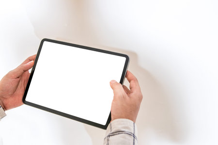 An image with a man holding a white blank screen tablet for mockup