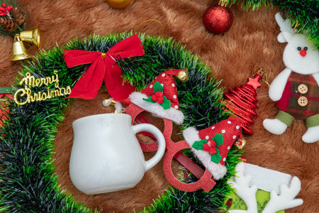 Blank white mug mockup image with christmas decorations. A blank white mug encircled by christmas ornaments, colorful gift decorations. Blank space to fill. Christmas mug mockup imageの写真素材