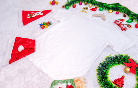 Blank white shirt mockup image with christmas themed decorations. A blank shirt encircled by christmas ornaments, colorful gift decorations. Blank space to fill. Christmas shirt mockup imageの写真素材