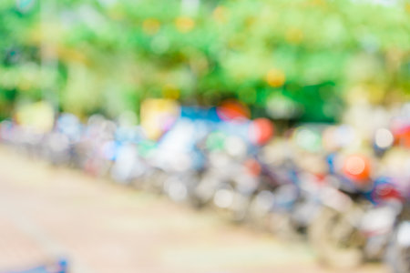 Defocused abstract background of a lot of motorcycles at the parking area. Blurred out park area backgroundの写真素材