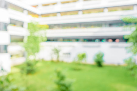 Defocused abstract background of a building with few plants in the frame. Blurred out building area backgroundの写真素材