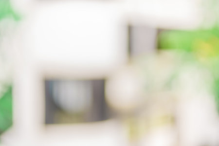 Defocused abstract background of some plants with a white building close to it. Blurred out building area backgroundの写真素材