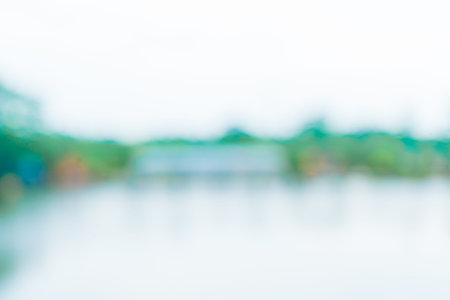 An out of focus a building near a river surrounded by a lot of trees, taken in the mid day, blurred out abstract backgroundの写真素材