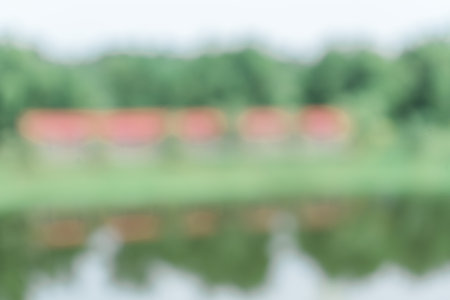 An out of focus a building near a river surrounded by a lot of trees, taken in the mid day, blurred out abstract backgroundの写真素材