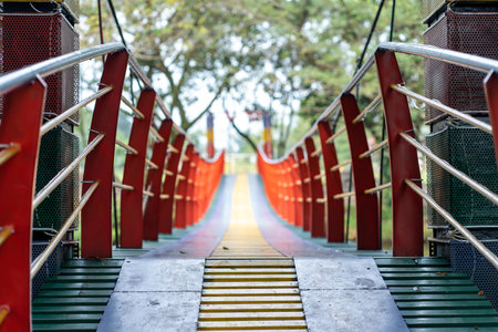 Perspective view of a bridge that leading to a park with out of focus park as the background, taken...