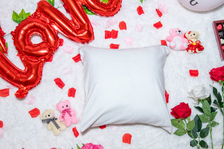White blank pillow above a a fluffy white carpet surrounded by valentine themed decorations