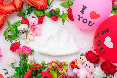 White blank beanie above a fluffy white carpet surrounded by valentine themed decorations