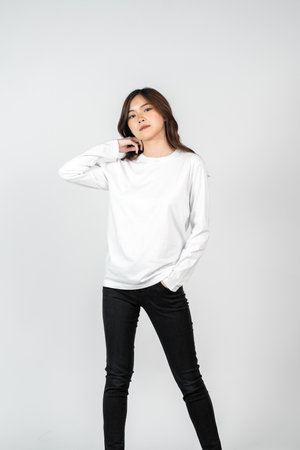 An asian woman wearing a white blank long sleeve shirt doing a pose, isolated on the white backgroundの写真素材