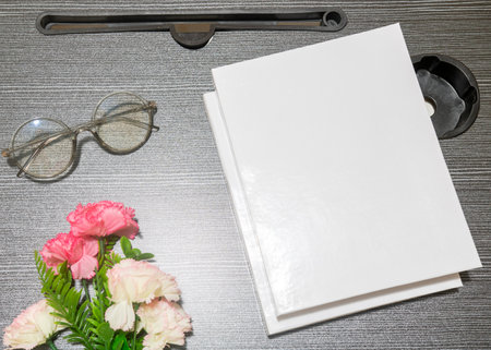 A white blank cover books laying on the top of a black table with a glasses near it, cover mockup template imageの写真素材
