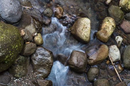 Exploring Nature's Beauty: Slow Shutter Speed Images of Water Flowing Among the Rocksの写真素材