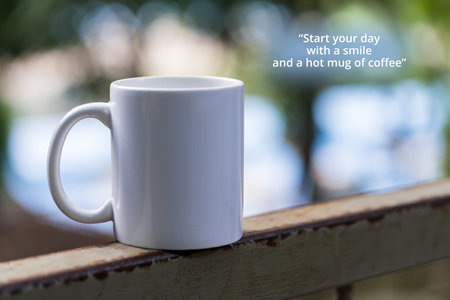 Coffee quote - Start your day with a smile and a hot mug of coffee. With a Mug at a wall fenceの写真素材