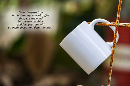 Drinks quote - Iron sharpens iron but a steaming mug of coffee sharpens the mind Let the two combine and fuel your day with strength, focus, and determination. With a mug hanging out of an iron wireの写真素材