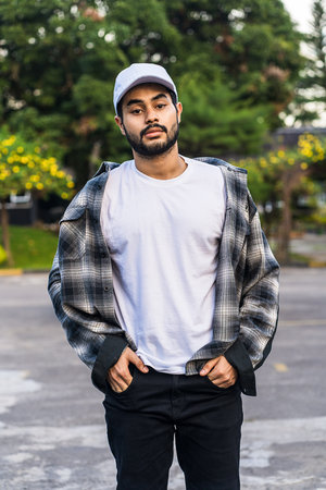 a bearded man strikes a pose while wearing a crisp and clean white blank shirt, exuding confidence and style, white blank cap hat and shirt mockup imageの写真素材