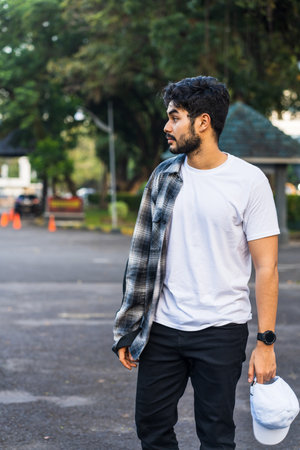 The bearded man in this captivating image showcases his style and masculinity in a white blank shirt, making a statement without saying a word, white shirt mug mockup imageの写真素材