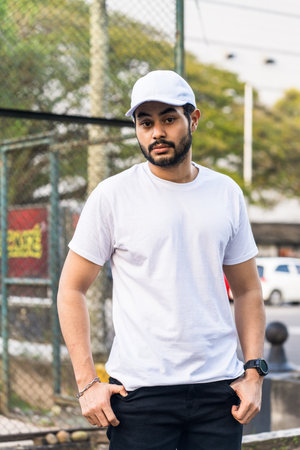 a bearded man posing confidently in a white blank shirt and matching white blank cap hat, creating a look that is both classic and modern, white blank cap hat and shirt mockup imageの写真素材