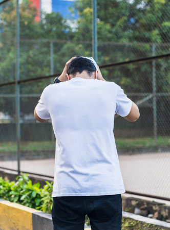 The simplicity of the back side white blank shirt worn by this bearded man allows his pose to take center stage, creating a bold and striking composition, white blank shirt mockup imageの写真素材