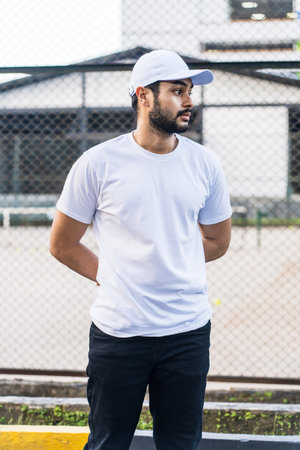 This image captures the essence of modern masculinity, with a bearded man confidently posing in a white blank shirt and cap hat, white blank cap hat and shirt mockup imageの写真素材