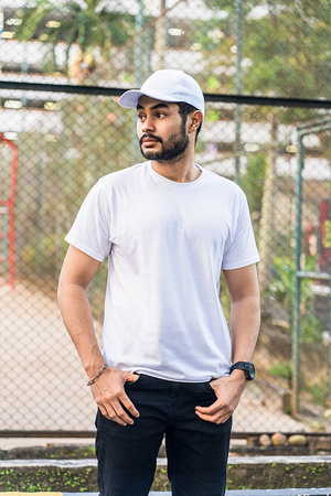The combination of a clean white blank shirt and cap hat create a bold and stylish look for this bearded man, making him the center of attention, white blank cap hat and shirt mockup imageの写真素材
