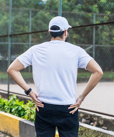 With his rugged beard and confident pose, this man creates a powerful and alluring image in a white blank shirt and cap hat, white blank cap hat and shirt mockup imageの写真素材