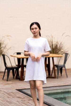Captivating portrait of an Asian woman in a cafe environment, shirt dress mockup template imageの写真素材
