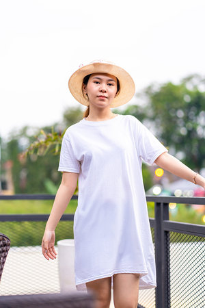 Serene portrait of an Asian woman in a picturesque location, shirt dress mockup template imageの写真素材