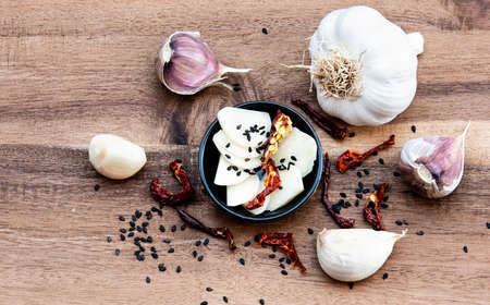 Garlic and dried chili peppers on a wooden boardの写真素材