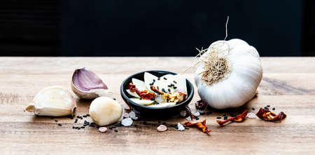 Garlic and dried chili peppers on a wooden boardの写真素材