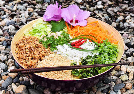 BÃºn bÃ² Nam Bá», a salad of thin rice noodles, lettuce, fried beef, onions, bean sprouts and other vegetables and herbs, topped with broth and sprinkled with crushed peanuts and fried shallots.の写真素材