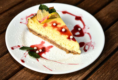 Luxurious cheesecake with lime and fruit on a white plateの写真素材