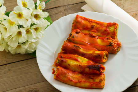 cannelloni pasta with ricotta and spinach on a wooden backgroundの写真素材