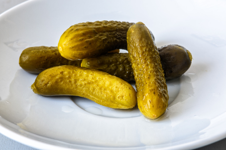 pickled gherkins on a white plateの写真素材