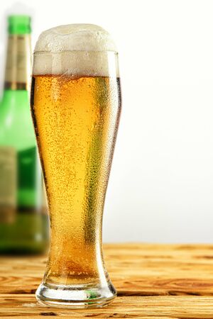 close up on an old wooden table. Bottle of beer in the backgroundの写真素材