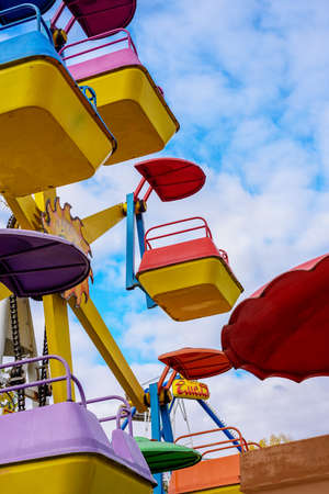 carousel attraction in a city Park without people on the background of a blue sky with cloudsの写真素材
