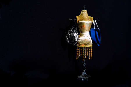 small mannequin with masks like shopping bags on its armsの写真素材