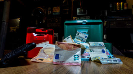 euro banknotes next to a small safe deposit boxの写真素材