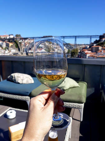 womans hand raising a glass of wineの写真素材