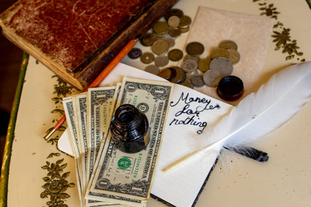 metal coins and dollar bills on a notebook in which money for nothing is written