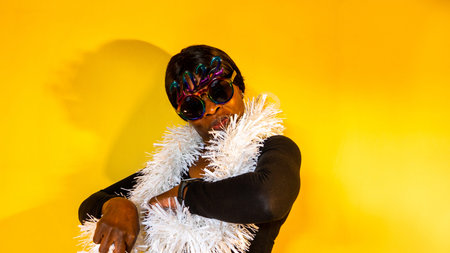 African woman with dark sunglasses in which the 2022 numbers are seen with a white boa surrounding...