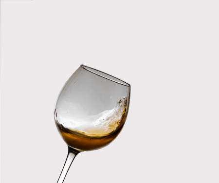 white wine glass in motion with bluish-white backgroundの写真素材
