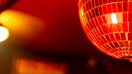 sphere that is covered with small mirror rectangles that reflect the colored lights in the...
