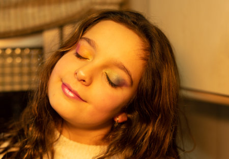 girl with her eyes closed showing her eyelids painted with the colors of the rainbowの写真素材
