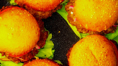 Five homemade hamburgers on black plate closeup macroの写真素材