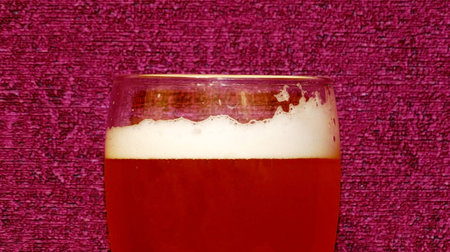 beer is poured into a glass and beer foam begins to drain on the glassの写真素材