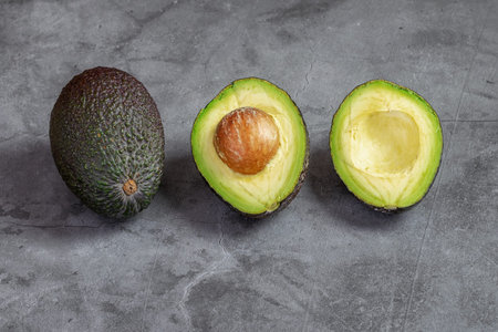 Ripe fresh green avocado on the black background. Healthy food concept.